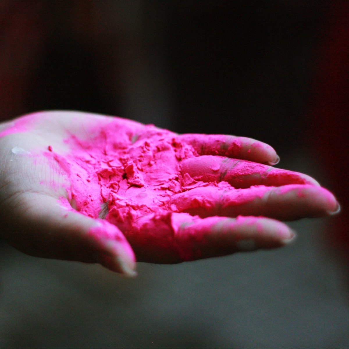 A hand covered in pink makeup product.